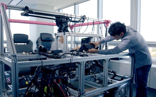 An engineer working on a vehicle test rig