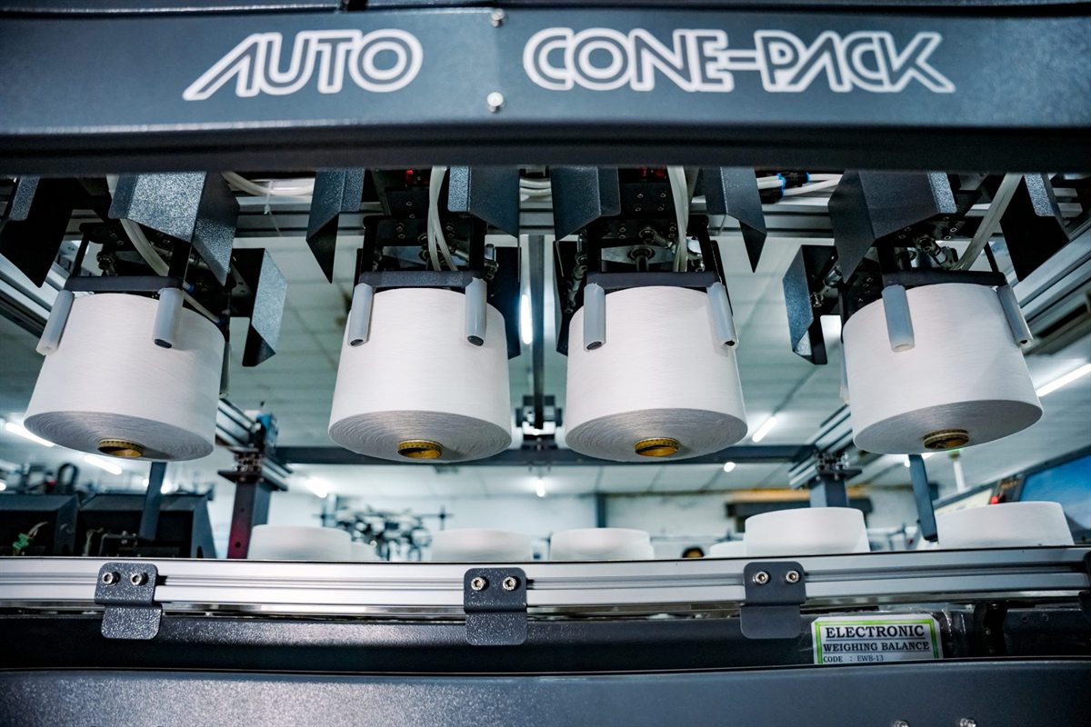Automated cone packing on a spinning line